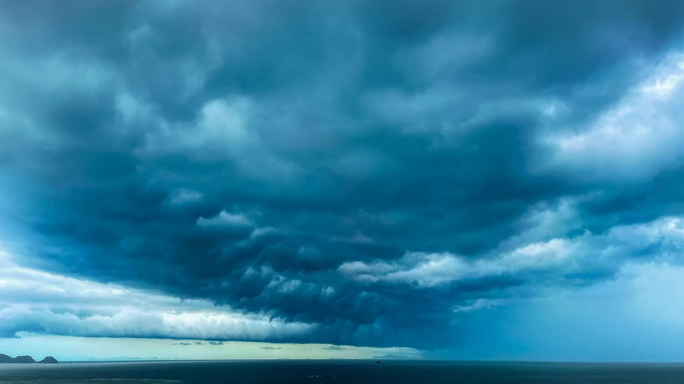 Dunkle Sturmwolken über dem Meer, Ausschnitt auf den hellen Horizont und das dunkle Wasser